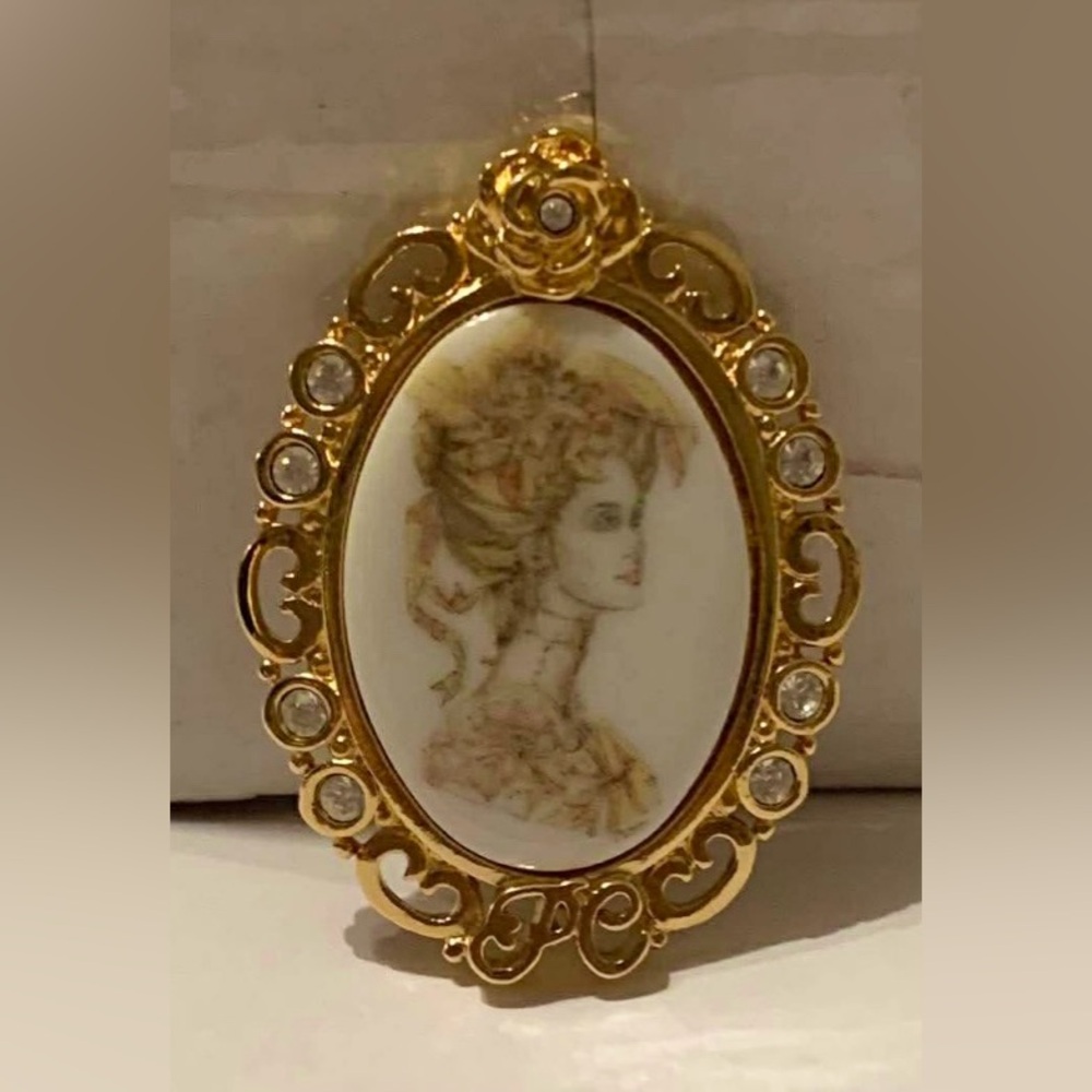 Vintage  porcelain Cameo surrounded by Rhinestones in a gold tone setting
